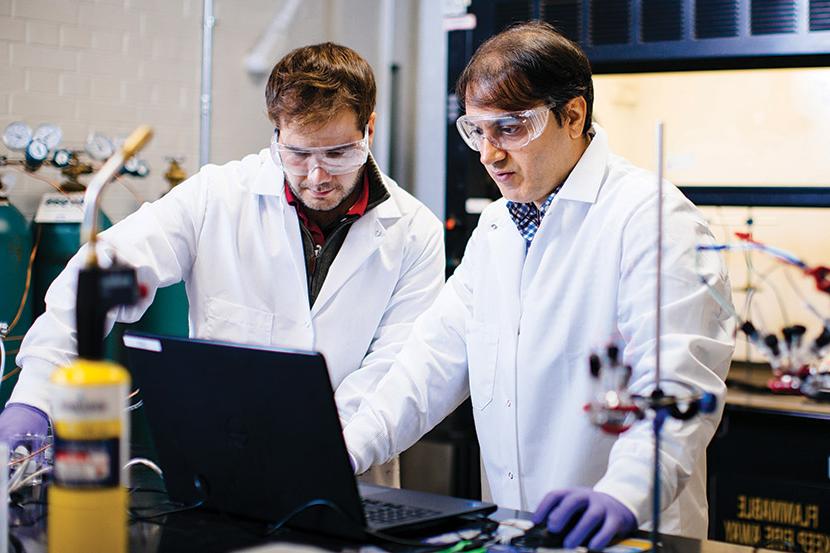 A graduate faculty member working with a student inside an engineering lab