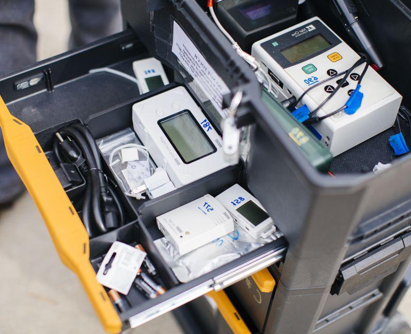 A tray of instruments sits in a cart in a lab space